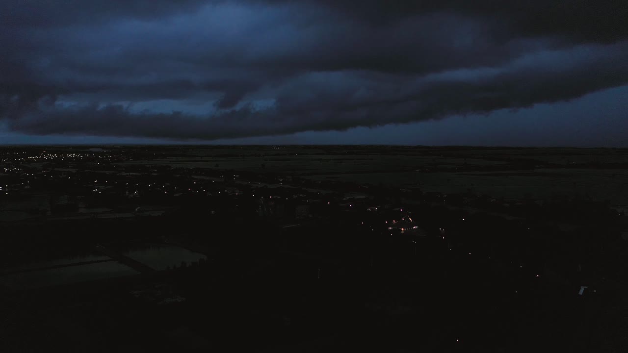 Letecký záběr z jeřábu na večerní bouři nad deltou Mekongu ve Vietnamu, od světla do tmy.