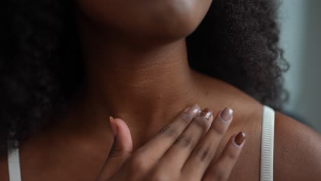 woman applying cream to her neck and chest