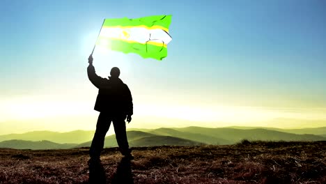 exitoso silueta hombre ganador agitando la organización de la unidad africana bandera en la parte superior del pico de la montaña, cinemagraph bucle de fondo