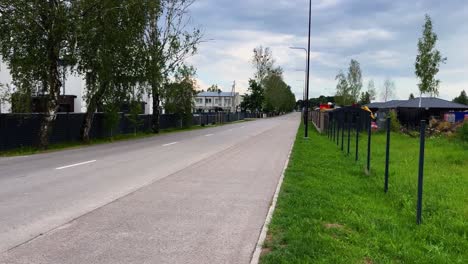 женщина с ребенком в коляске в районе частных домов в окрестностях