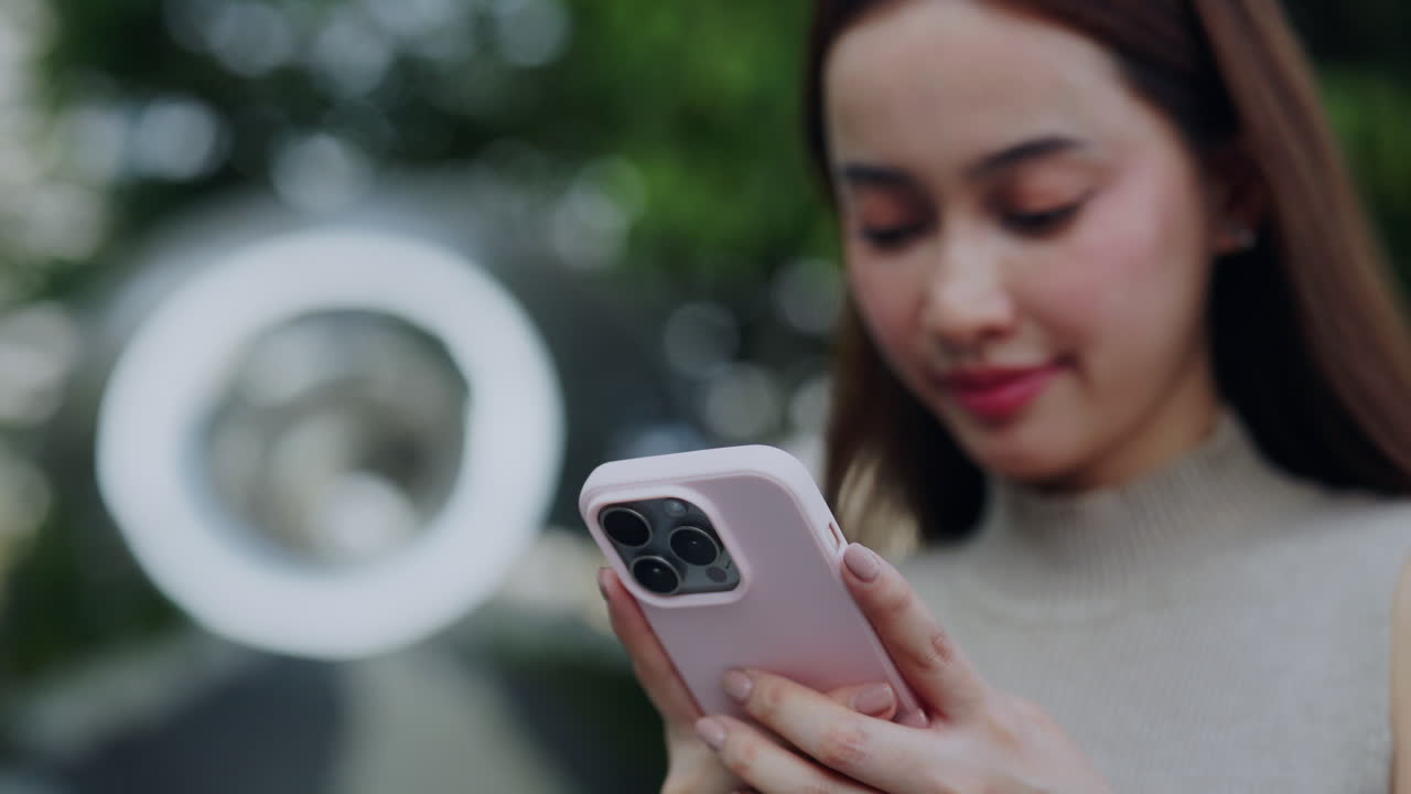 Giovane donna asiatica che usa lo smartphone all'aperto