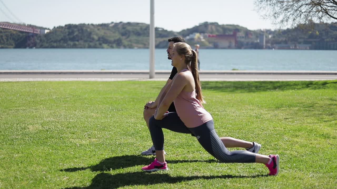 una pareja deportiva entrenando juntos en el parque soleado de verano.
