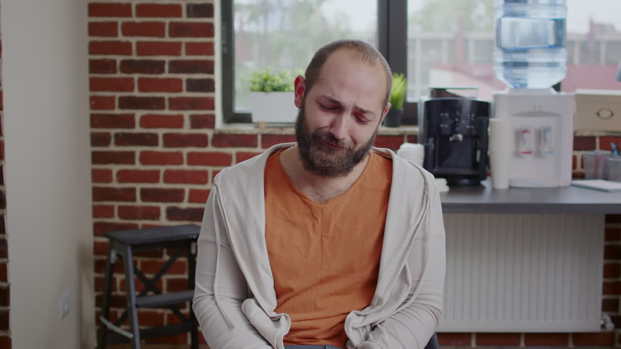 Man with addiction having nervous breakdown in front of people at aa group therapy, crying