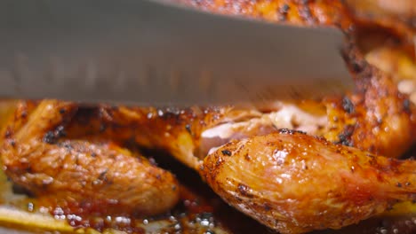 chef carving roast chicken leg from whole roasted bird with seasoned crispy skin. traditional british sunday lunch dinner.