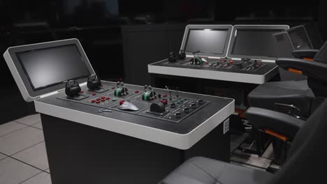 modern, high-tech control consoles with monitors and joysticks stand ready for use in a maritime navigation simulator training center at a university