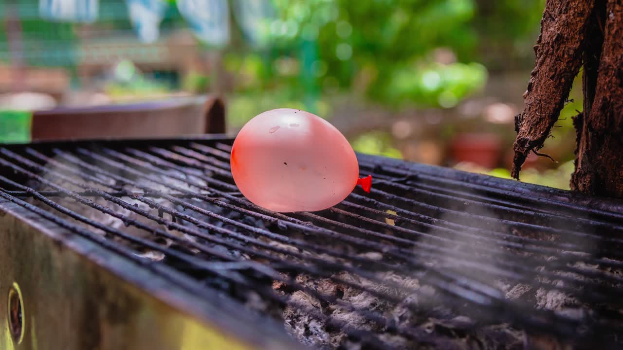 뜨거운 bbq 그릴에서 방출되는 연기의 시네마그래프에 물 풍선이 배치되어 있습니다.