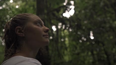 a candid, side-profile shot of a woman with her hair in a ponytail, looking upward and slightly away from the camera