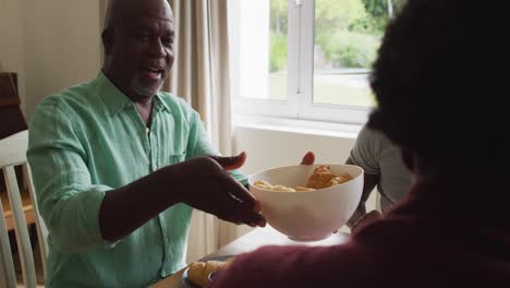tres generaciones de una familia afroamericana desayunando juntos en casa
