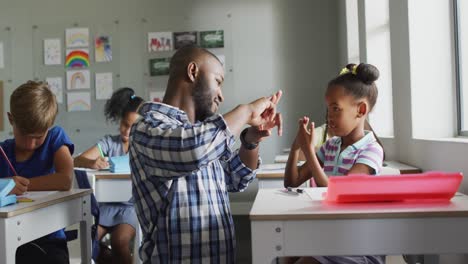 Video-Einer-Glücklichen-Afroamerikanischen-Lehrerin,-Die-Einem-Afroamerikanischen-Mädchen-Im-Klassenzimmer-Das-Zählen-Beibringt