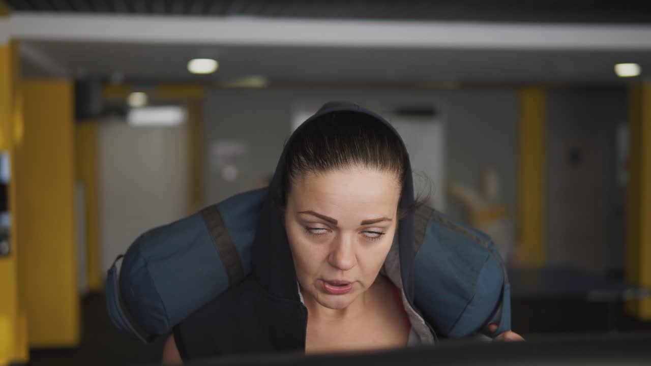 Wanita Berolahraga di Treadmill dengan Ransel Berbeban