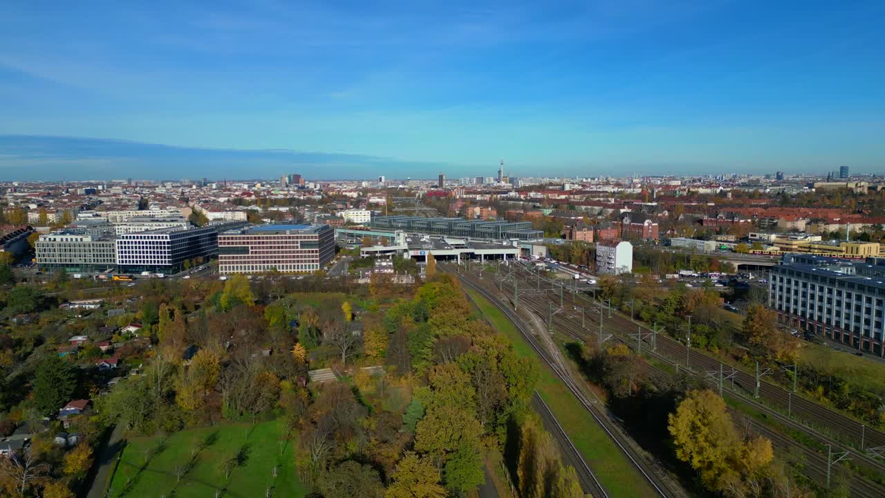 Berlin cityscape with a modern train station South Cross and extensive railway lines under a clear sky. Fantastic aerial view flight descending drone