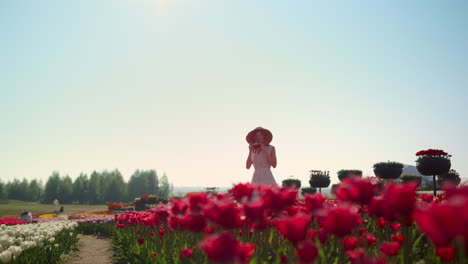 beautiful park with flowers and girl taking photos. woman walking in tulip field