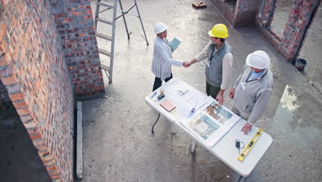 construction team shaking hands on building site