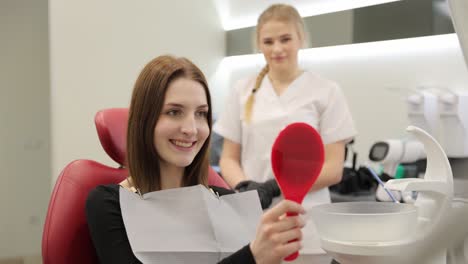 a joyful patient proudly displays her bright smile after a recent dental checkup, with the dentist nearby