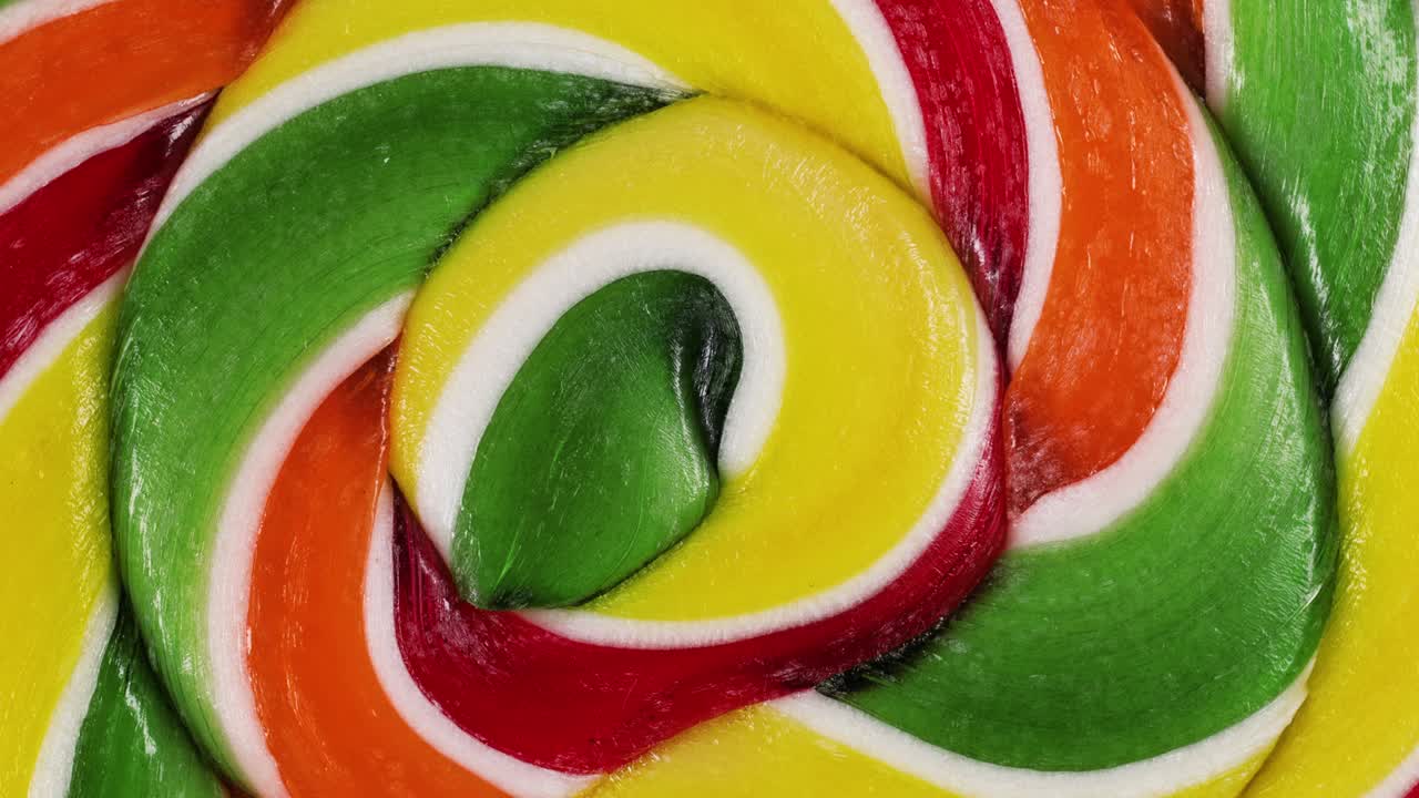Vue macro extrême d'une sucette spirale aux fruits en rotation. Sucettes au caramel. Friandises pour enfants. Concept d'enfance.
