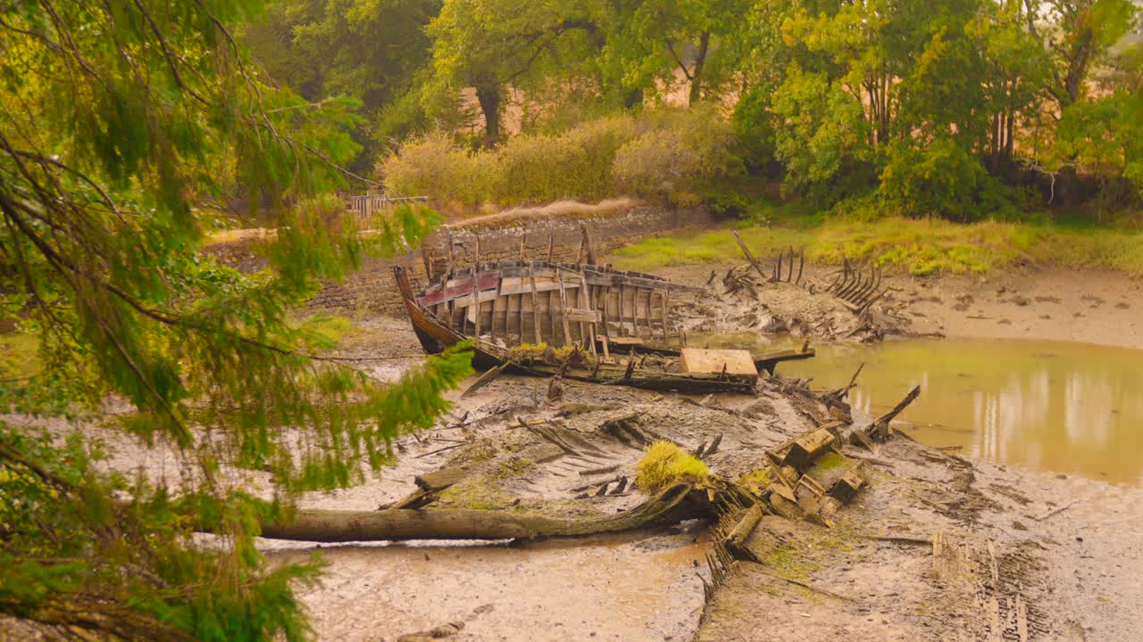 Dilapidated Wooden Boats In The Mudflats Of The Rivière du Bono (Bono River) In Brittany, France. Static Shot