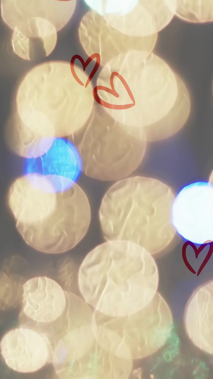 Video verticale: Punto blu che appare, bokeh caldo che si sposta, lustrini scintillanti, cuori che si diffondono, aggiungendo gioia.