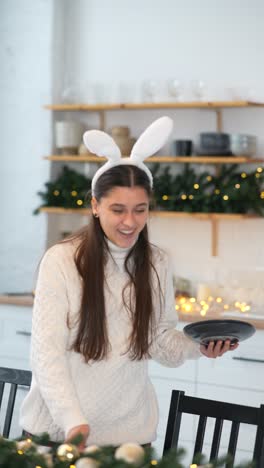 young woman in bunny ears setting a table for christmas