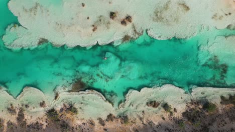 hombre bañándose en aguas termales, rápidos del río bacalar en méxico, 4k aéreo de arriba hacia abajo