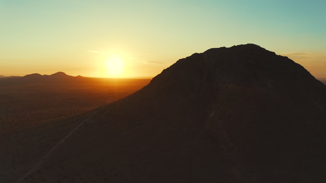 voando por trás de um pico de montanha no deserto de mojave para revelar o sol, em seguida, orbitando ao redor da montanha para uma visão aérea da vasta paisagem