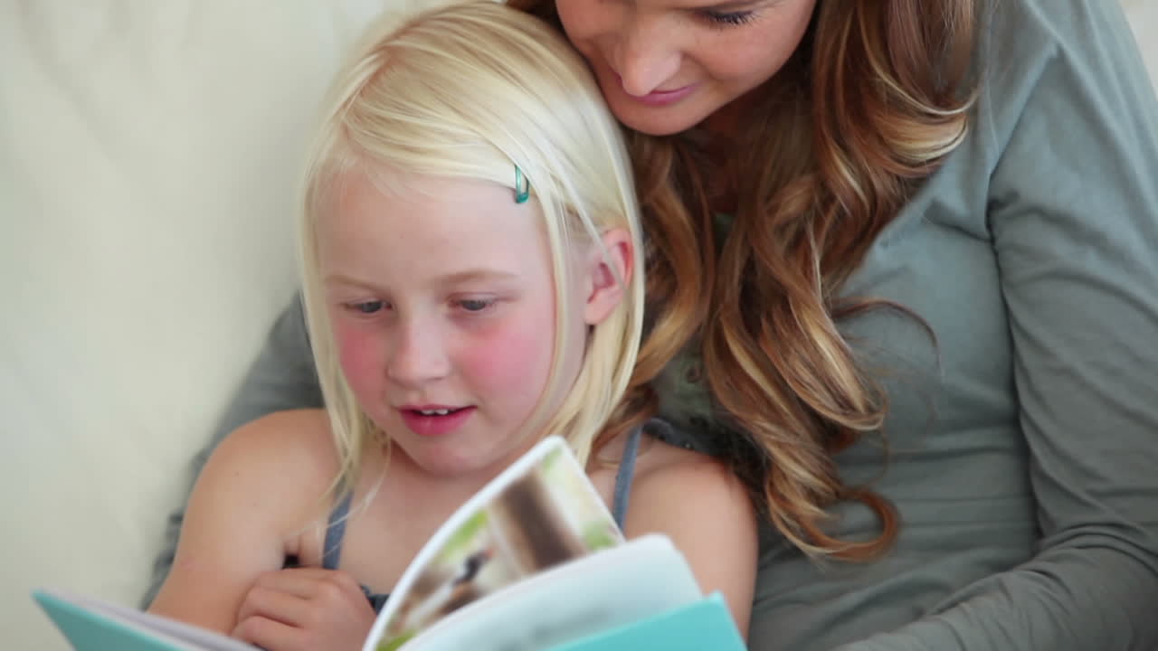 Mädchen liest ein Buch mit ihrer Mutter