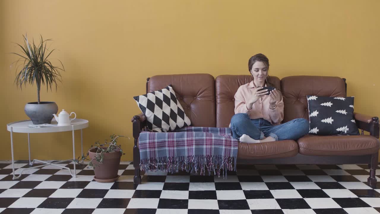 mujer usando el teléfono en un sofá en una sala de estar