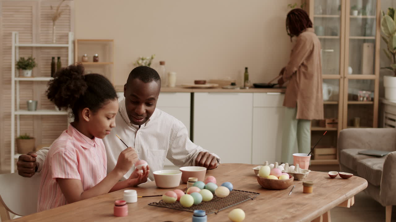 Father Watching Daughter Painting Easter Eggs