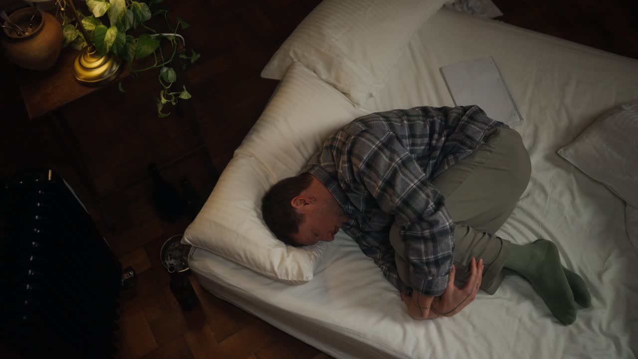 Man Sleeping Uncomfortably in a Bed