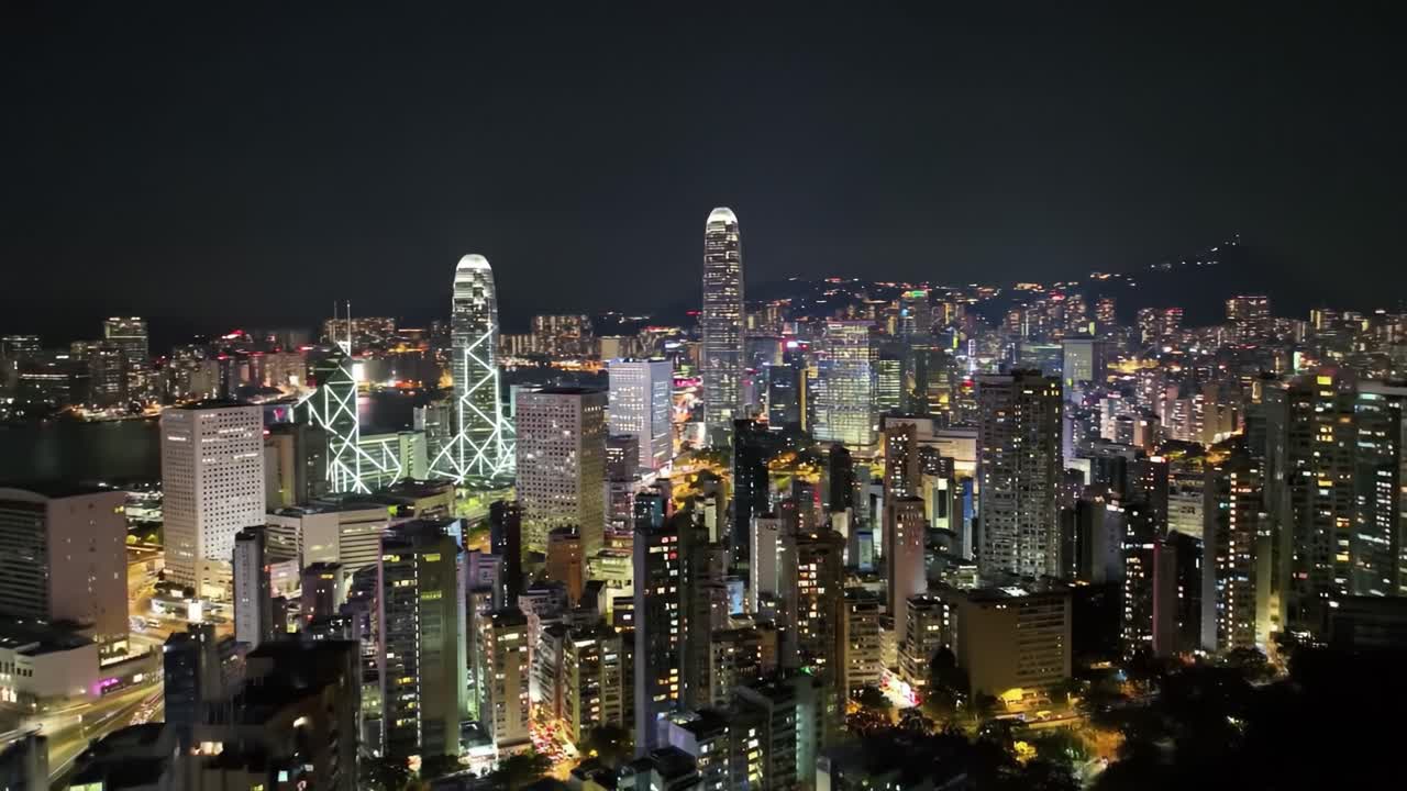 This captivating view showcases the stunning skyline of Hong Kong during the night, featuring illuminated skyscrapers and a bustling urban landscape. The city buzzes with life and energy.