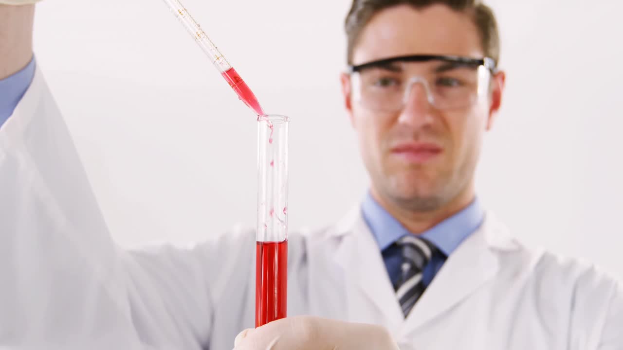 técnico de laboratorio chequeando una muestra de sangre en un tubo