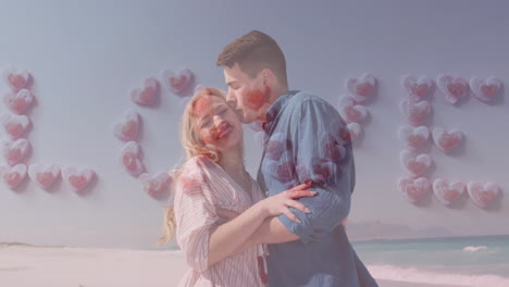 animation of love text formed with hearts over happy caucasian couple on beach by sea