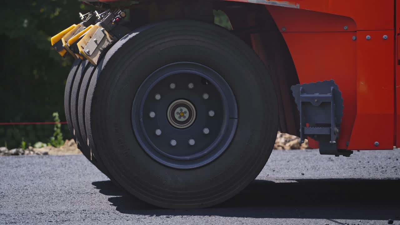 Fresh asphalt construction. Close view of the road roller working on the new road construction site