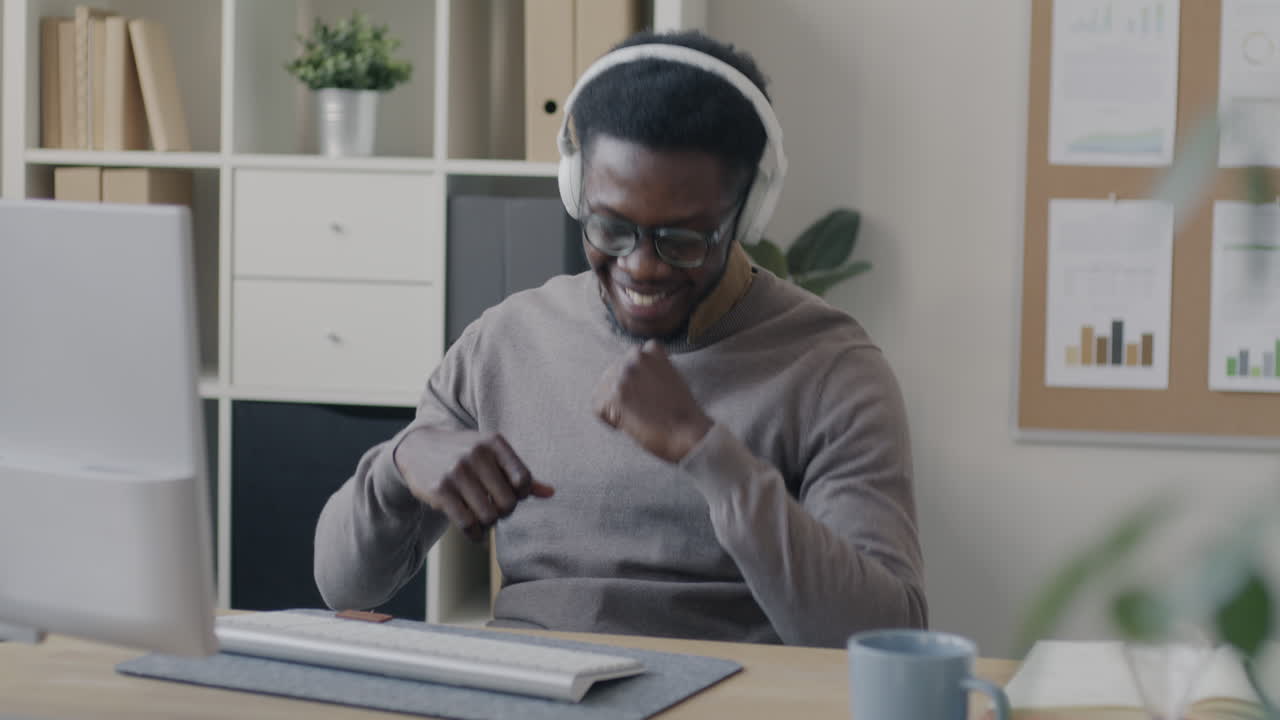 Lavoratore felice che ascolta musica alla sua scrivania