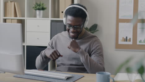 happy worker enjoying music at their desk