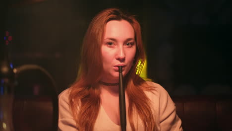 woman smoking hookah at nightclub