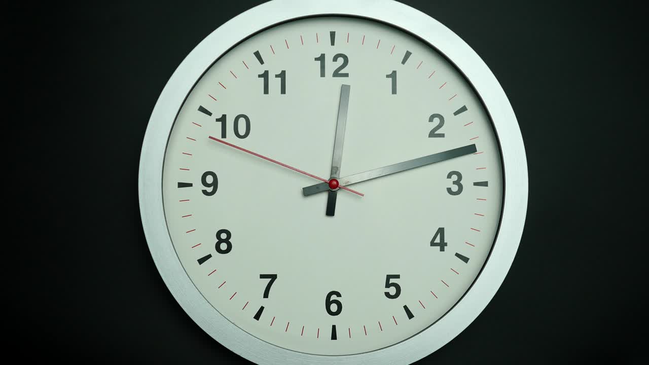 reloj gris aislado sobre fondo negro, hora del espectáculo 12: 13 am o pm.