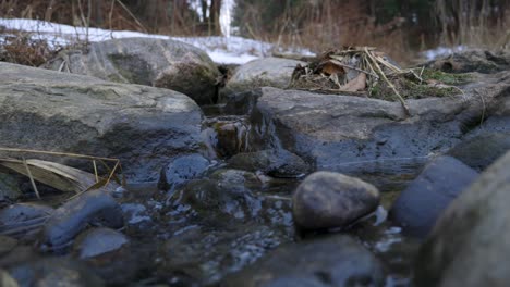 Agua-Que-Fluye-Sobre-Las-Rocas-A-Través-De-Un-Arroyo-Gorgoteante-En-Invierno