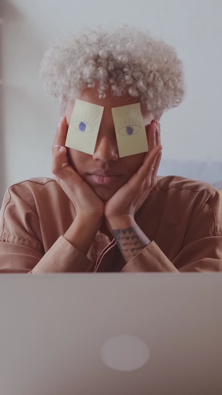 Young lazy african american woman sleeps with stickers on face sits at workplace