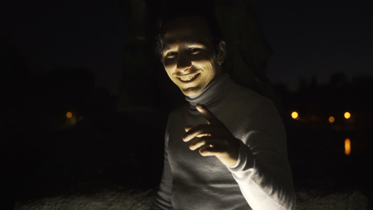 Scary smiling face in the dark, illuminated by light