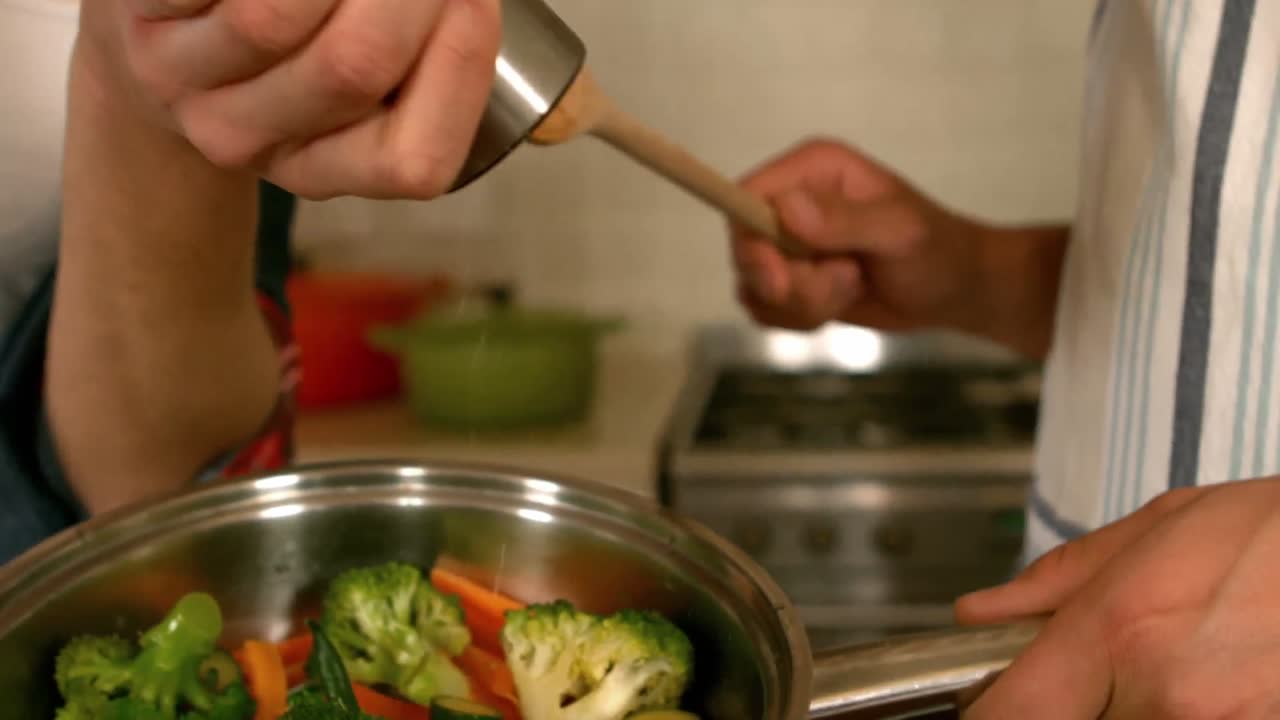una pareja feliz cocinando verduras juntos