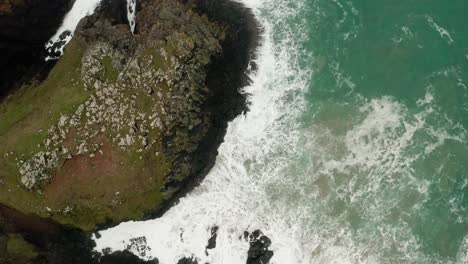 an aerial overhead orbit of the waves from the atlantic crashing into the shores of cornwall, england