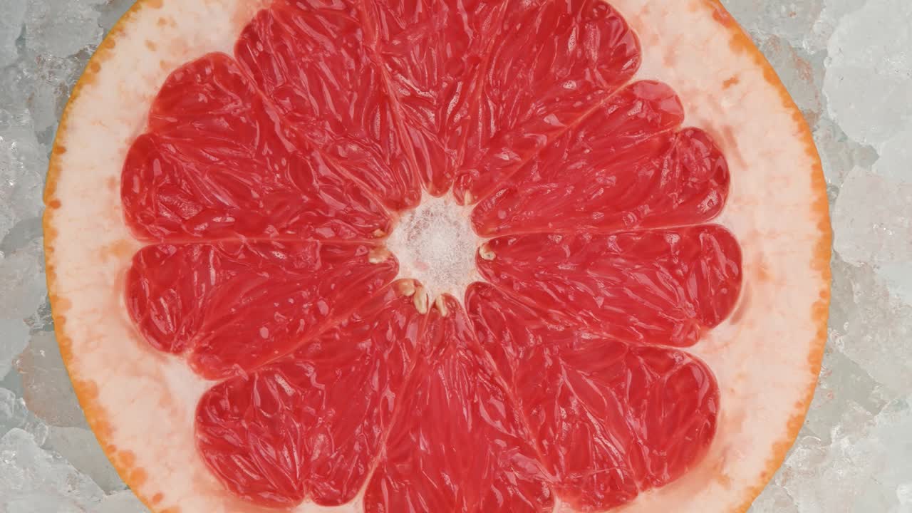 una rebanada de pomelo rosa fresca sobre hielo triturado