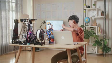 student working on robotics project with 3d printer and laptop