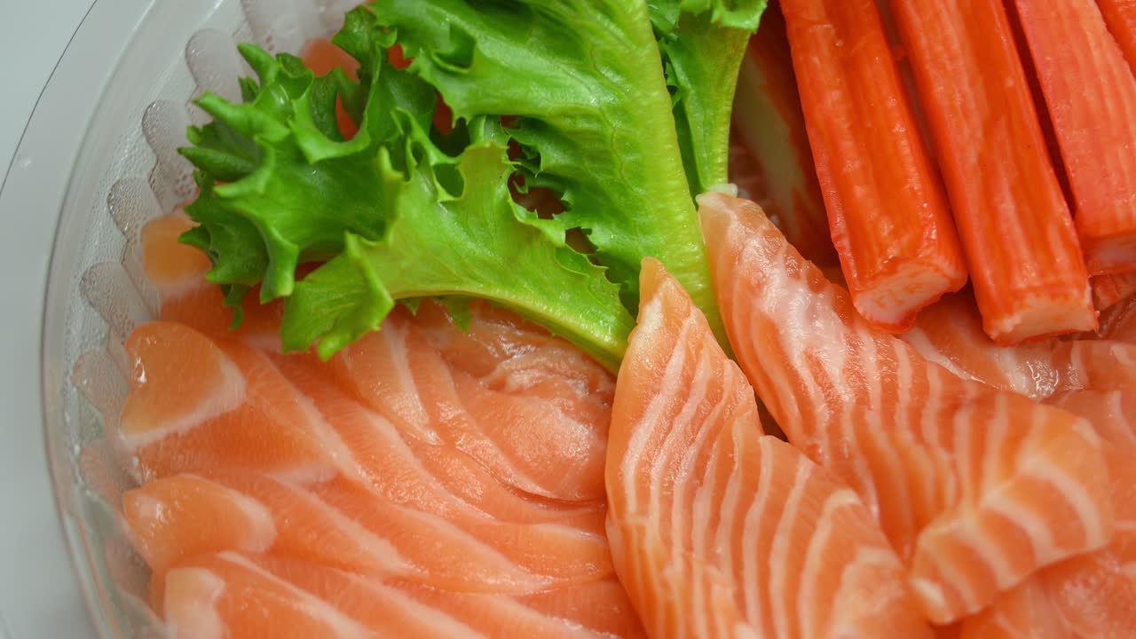 ensalada de salmón sashimi y palito de cangrejo en el plato
