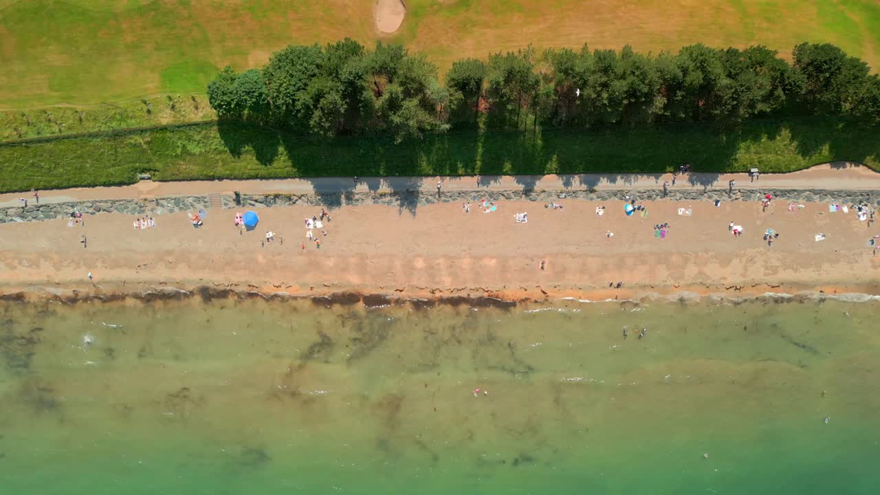 Top down aerial video of Helen's Bay beach in County Down, Northern Ireland, UK on a bright summer day. Filmed in 4K, 60FPS and with Rec709 color