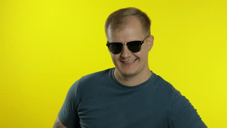 Retrato-De-Un-Joven-Posando-En-Camiseta.-Un-Chico-Guapo-Y-Genial-Usa-Gafas-De-Sol,-Tratando-De-Verse-Bien