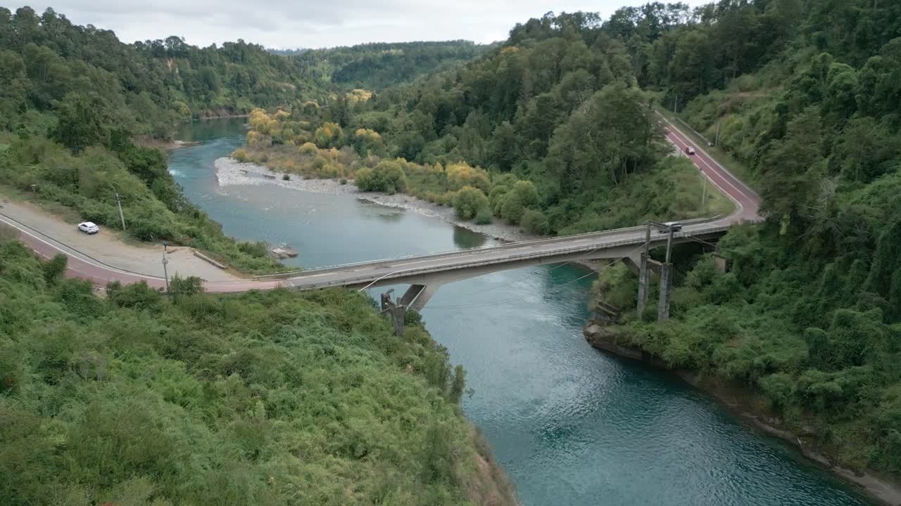 Ilmakuva turkoosista joesta sillan ja metsän ympäröimänä. Malihue, Los Lagos, Chile.