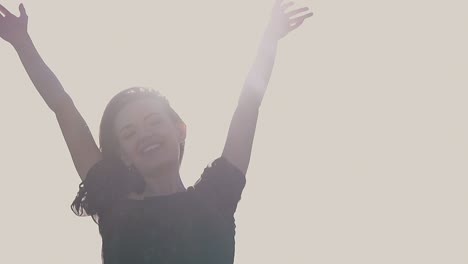 lady with raised hands poses at sunlight closeup slow motion