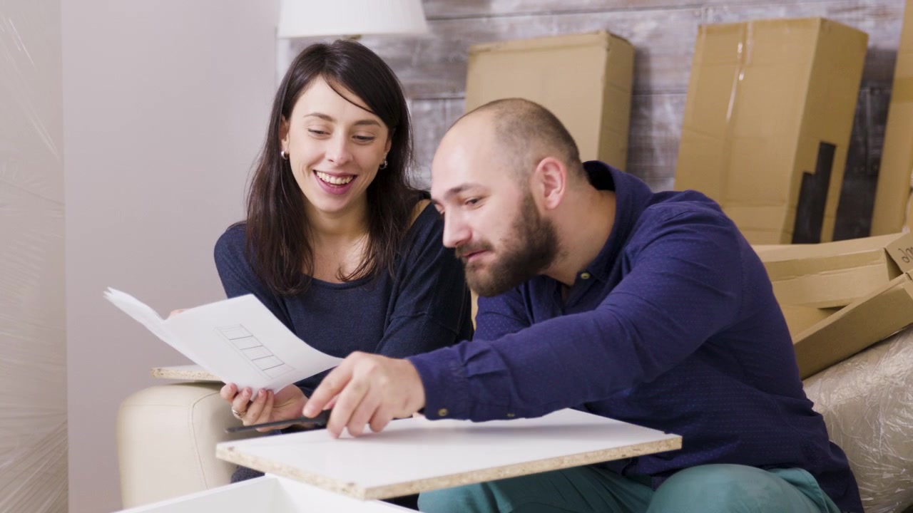 Pareja joven montando muebles juntos en su nuevo hogar