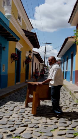 a man moving and preparing a wooden table on a cobblestone street